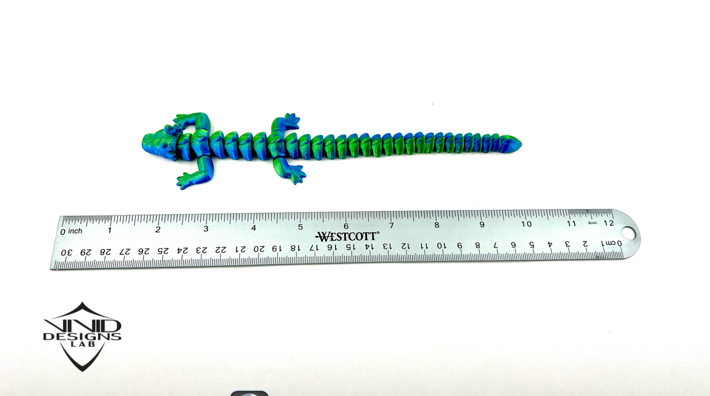 3D printed articulated dragon toy next to ruler with white background