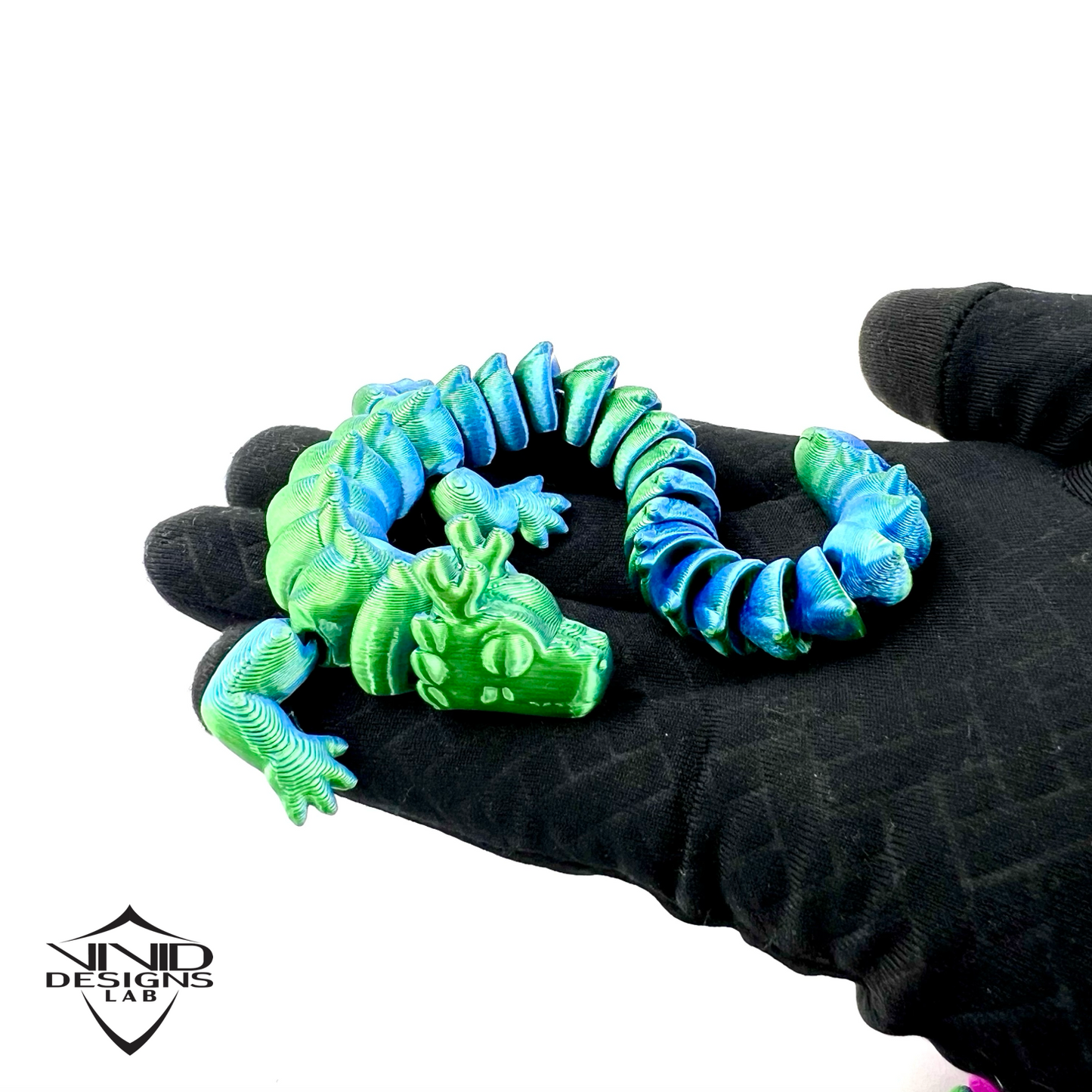 A colorful 3D printed toy articulated dragon sitting on hand with white background