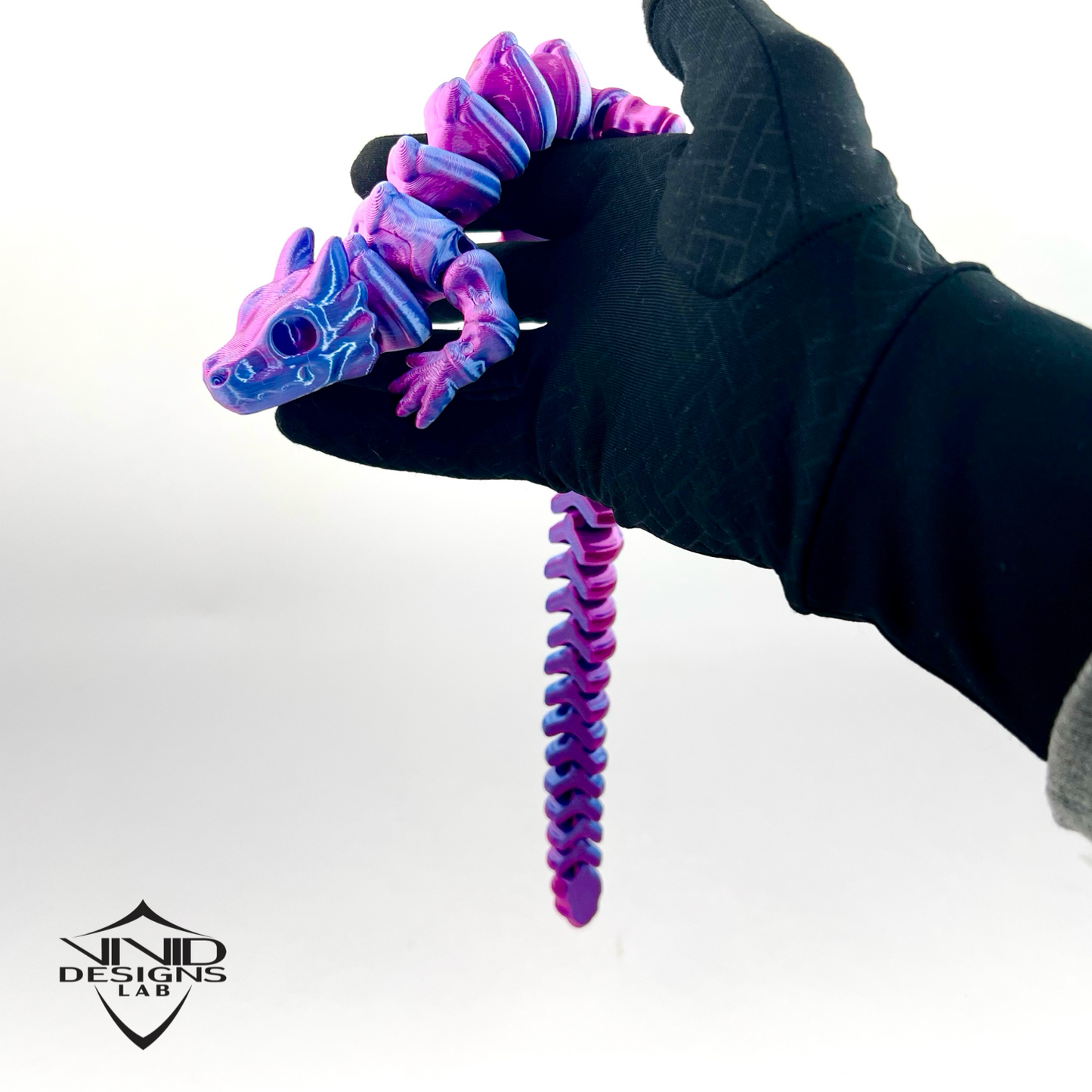 hand holding 3D printed articulated toy dragon that features shiny purple and pink look.