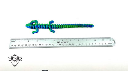 3D printed articulated dragon toy next to ruler with white background